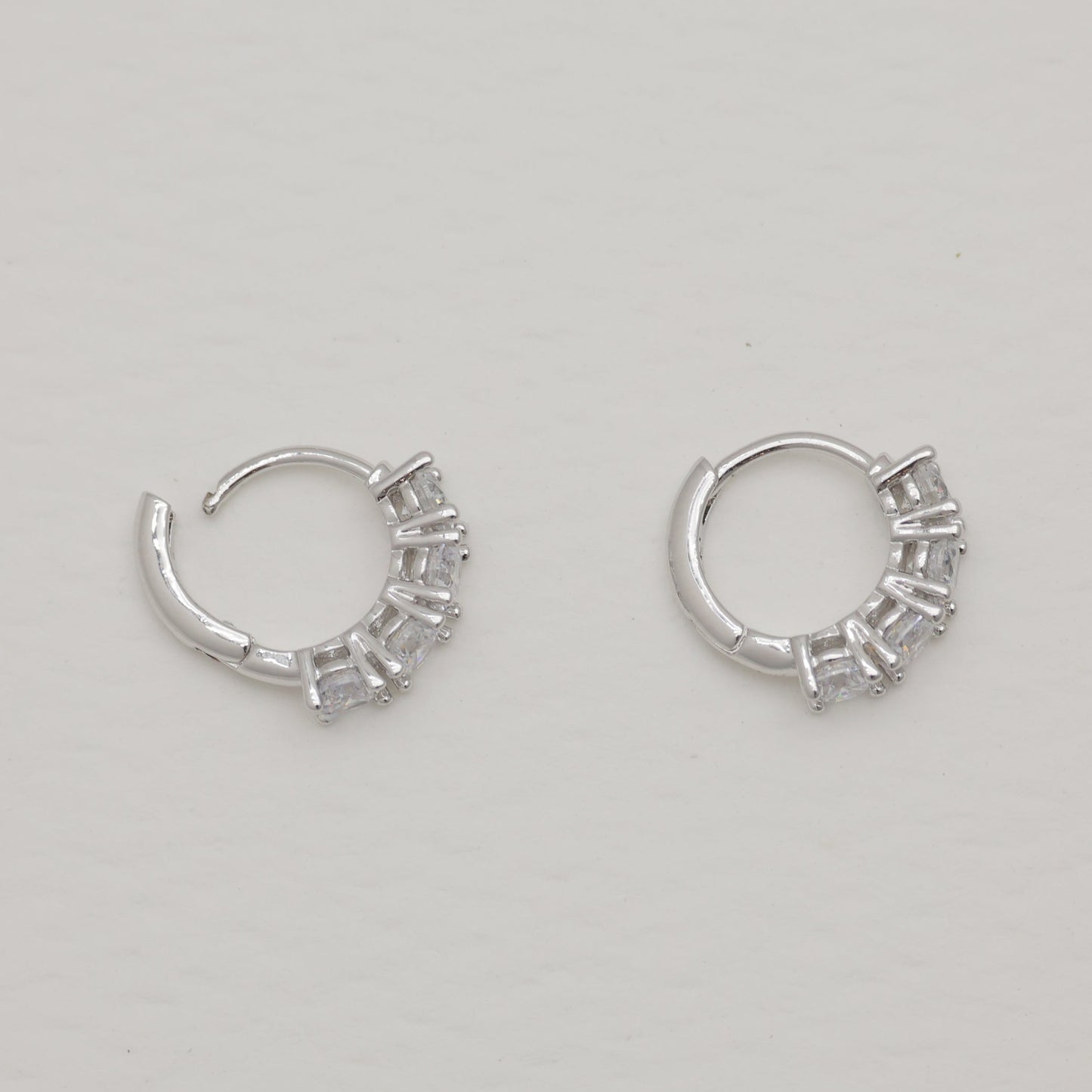 Pair of silver hoop earrings on a light gray background