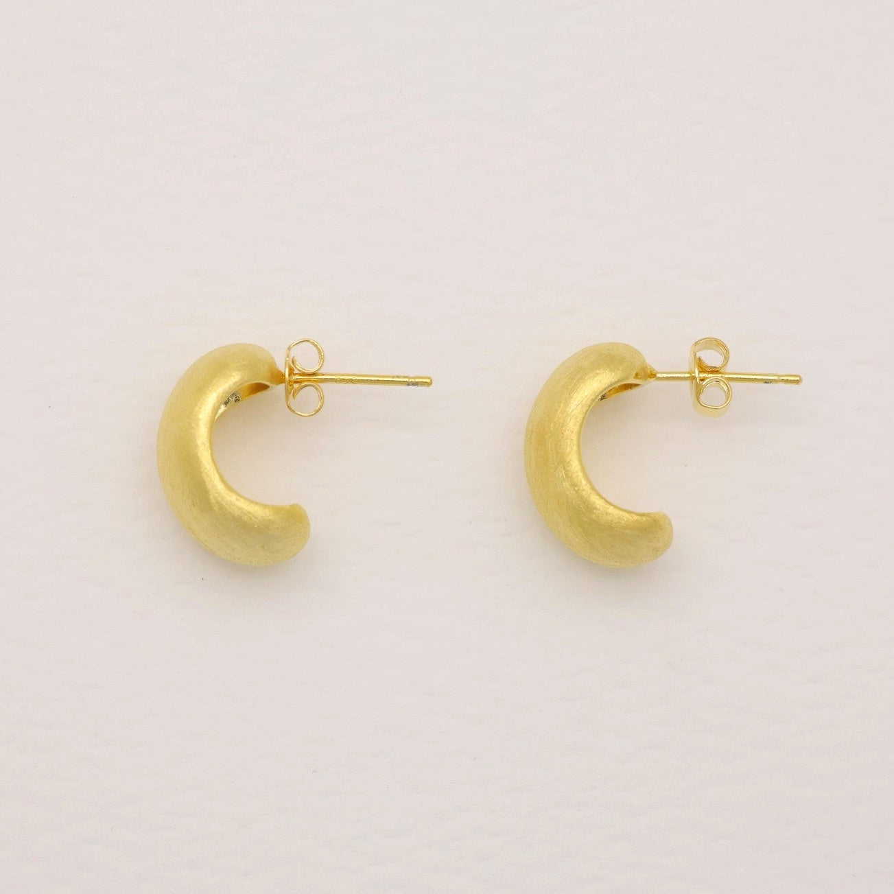 “Pair of gold vermeil matte dome earrings with push-back posts, top view.”