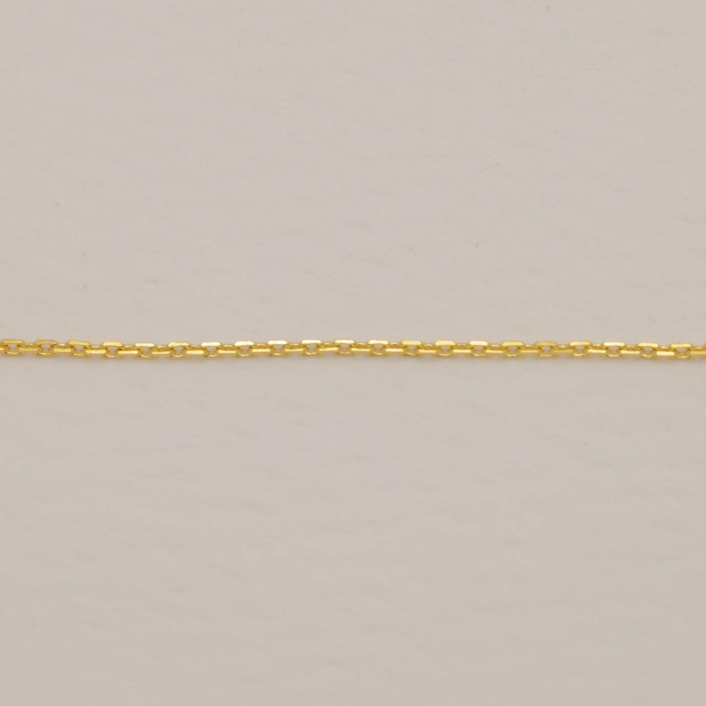 Gold chain on a beige background