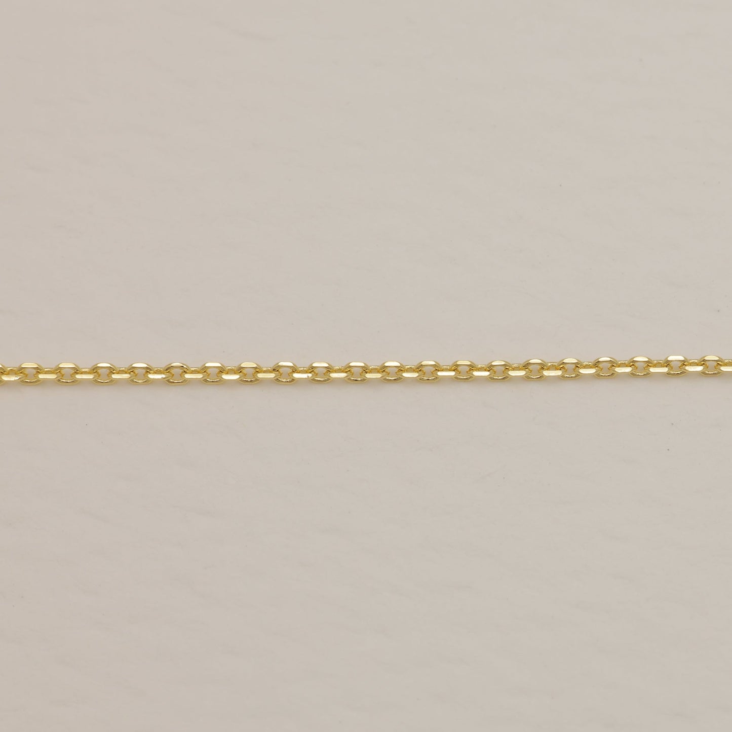 Gold chain on a beige background
