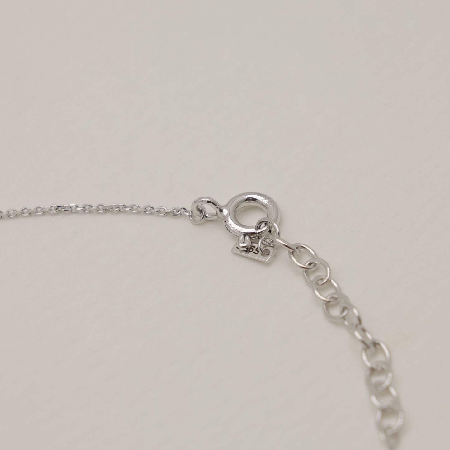 Close-up of a silver bracelet on a light gray background