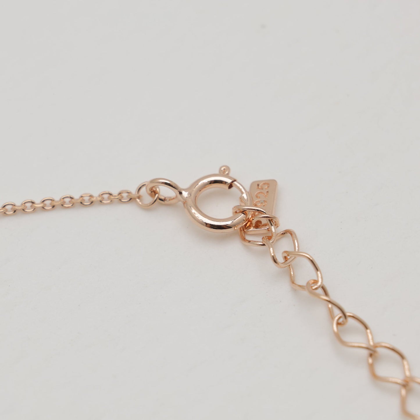 Rose gold bracelet on a light gray background