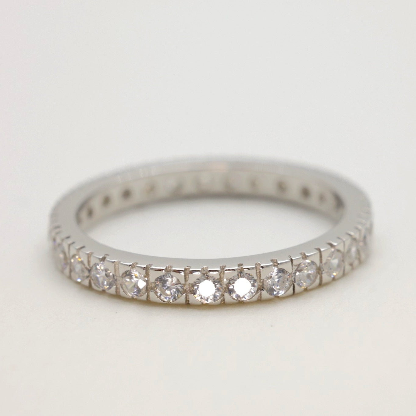 Close-up of the Aurore Pavé Ring in sterling silver, showcasing triple rows of cubic zirconia on a matte background.