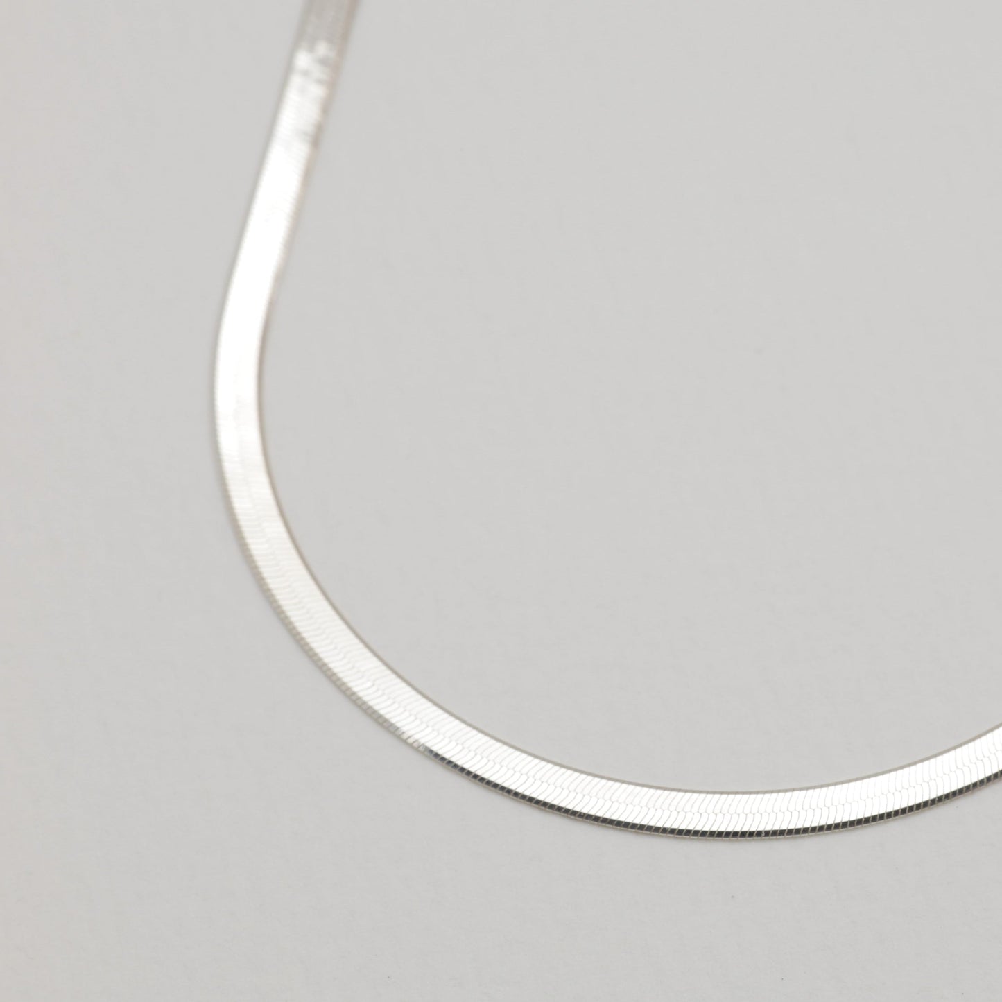 Close-up of the herringbone chain texture of the Margaux Necklace