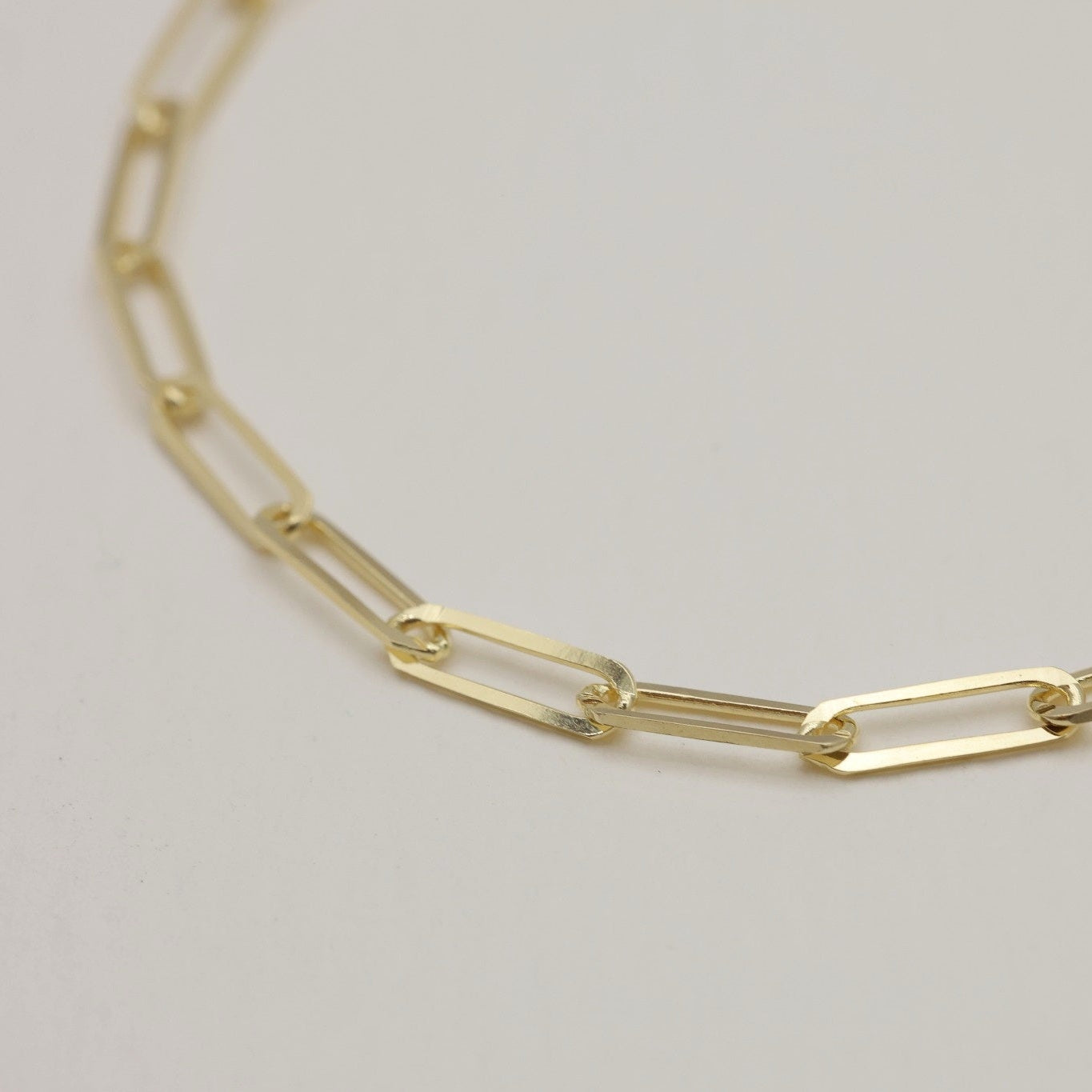 Detailed side view of the Clara Bracelet showcasing its polished gold finish.