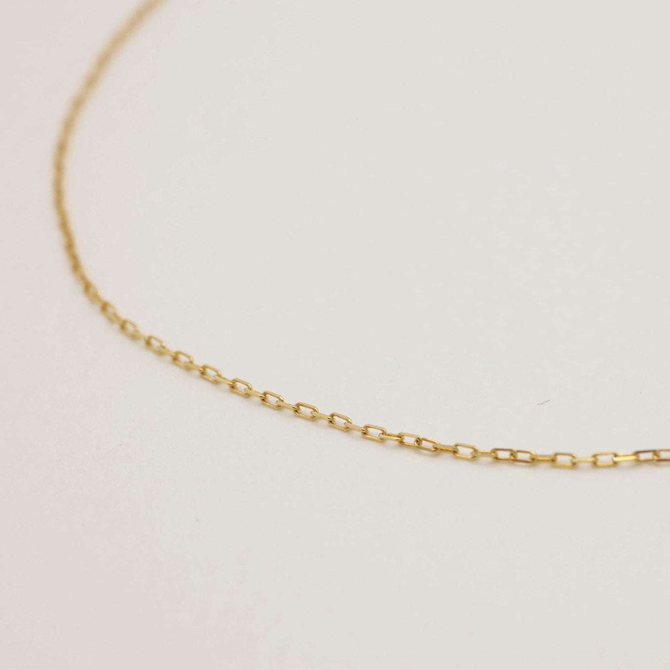 Close-up of the Émilie Chain Necklace in 18K gold, featuring delicate rectangular links and a polished finish.