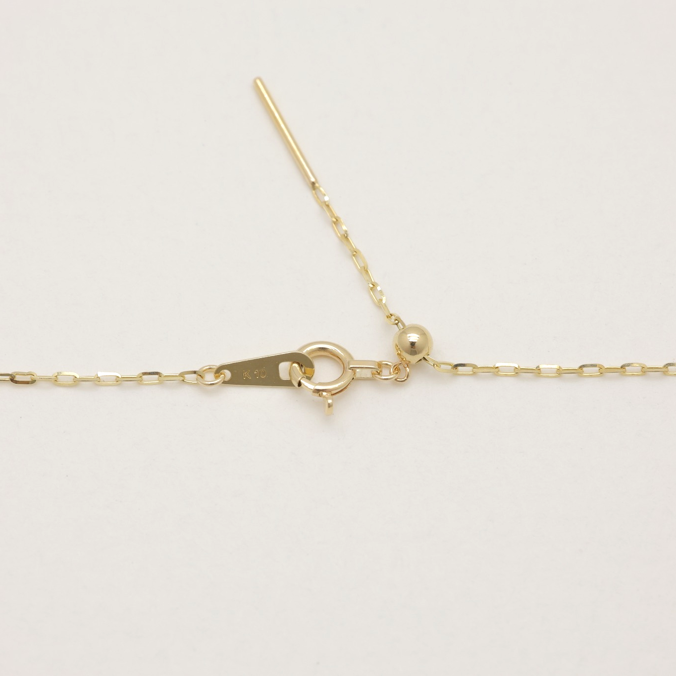 Macro shot of clasp and hallmark on 10K gold necklace, made in Japan