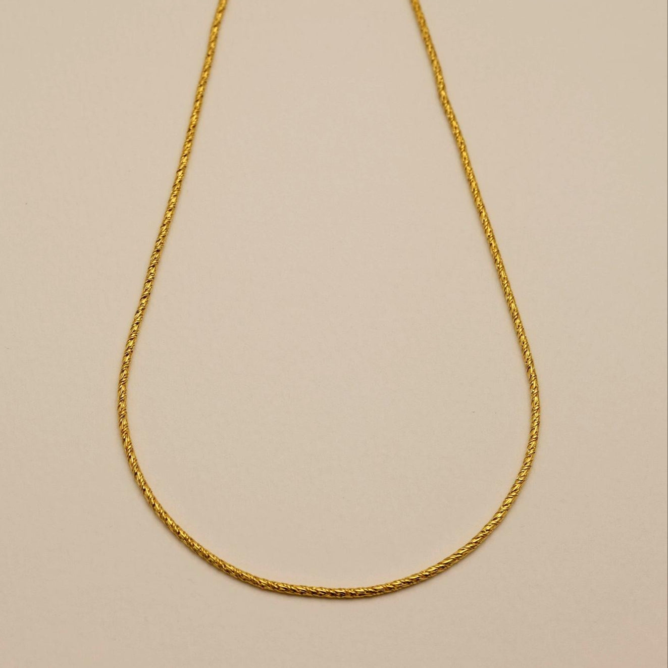 Flat lay of the full Érine Necklace with toggle clasp displayed at the top, capturing its classic yet modern silhouette.