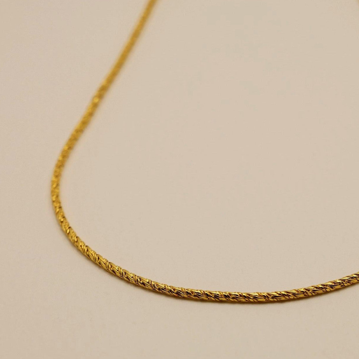 Detail view of the Érine Necklace toggle clasp, showcasing its twisted bar and elegant finish.