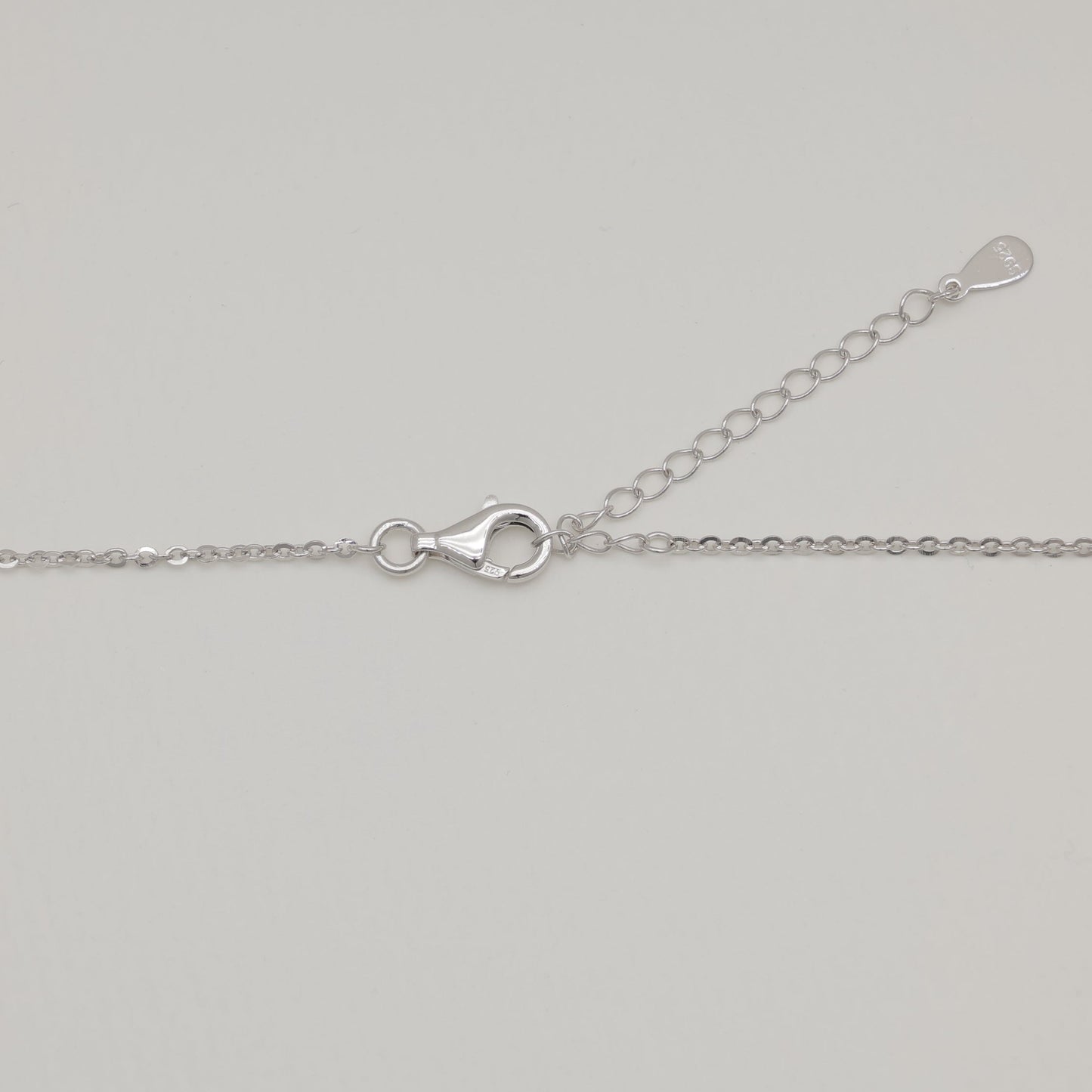 Silver chain necklace on a light gray background