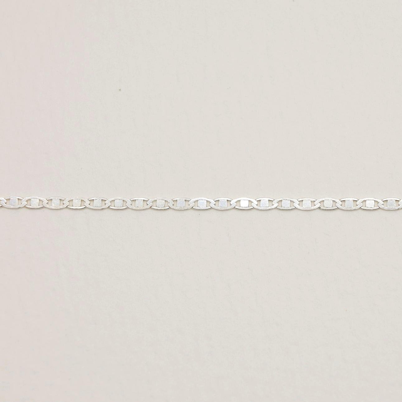 A close-up showing the fine rectangular link pattern of the Aliane Chain Necklace.