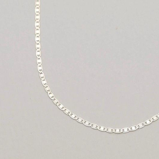 A close-up showing the fine rectangular link pattern of the Aliane Chain Necklace.