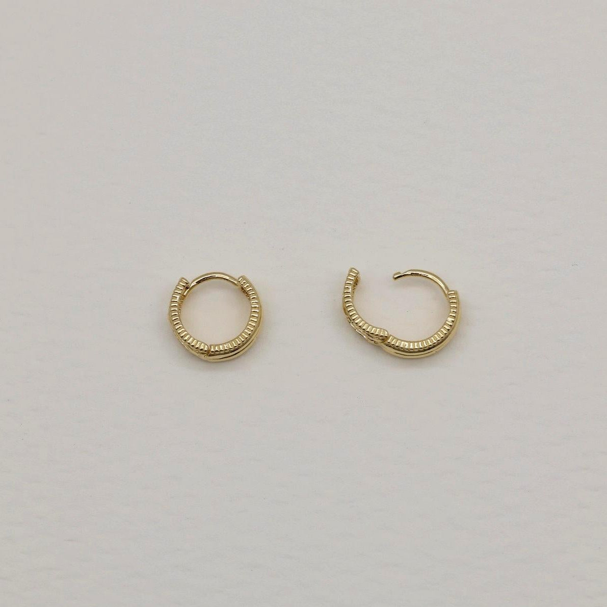 14K gold small hoop earrings with ribbed texture, front and side view on neutral background