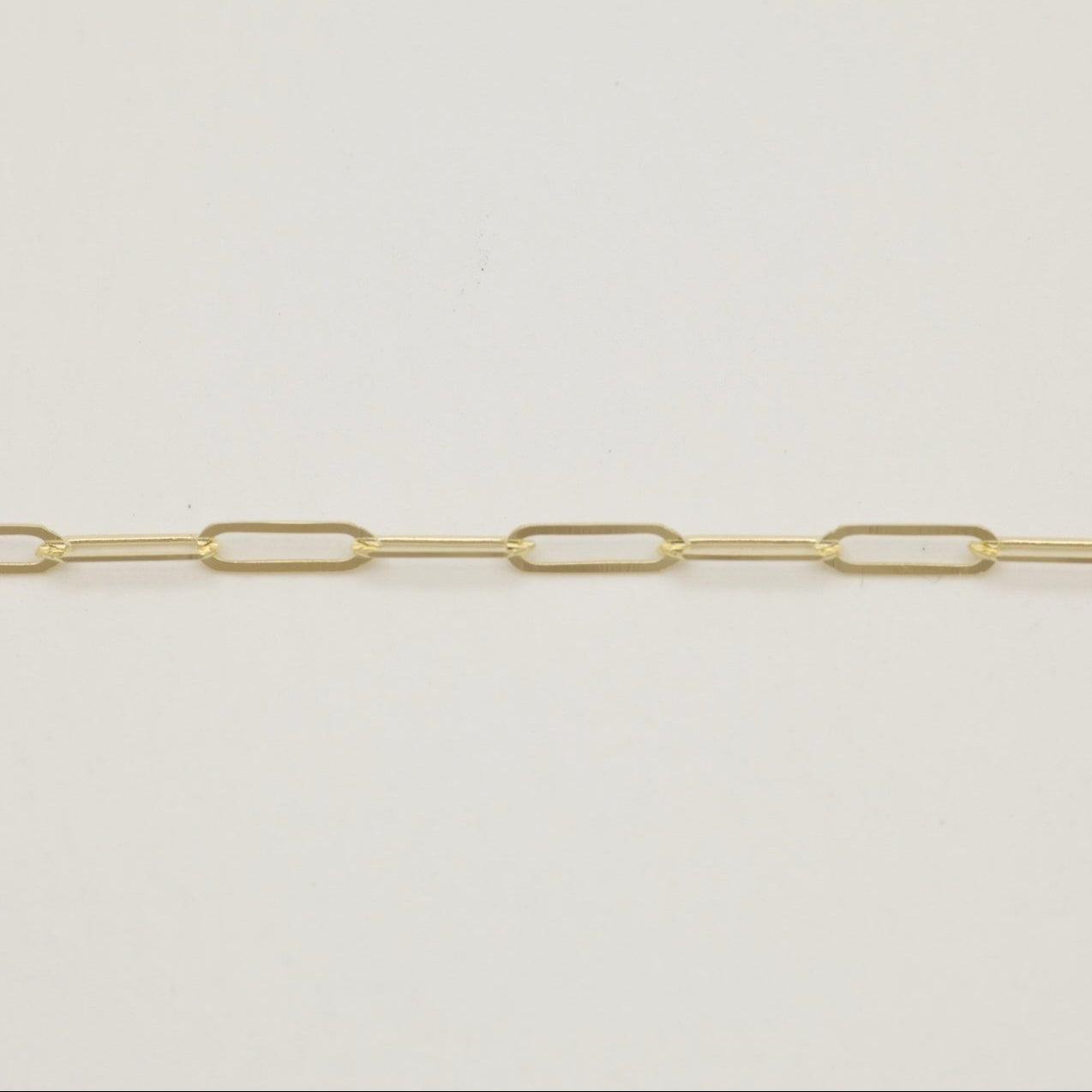 Close-up of 14K gold chain bracelet showing rectangular links and polished finish.