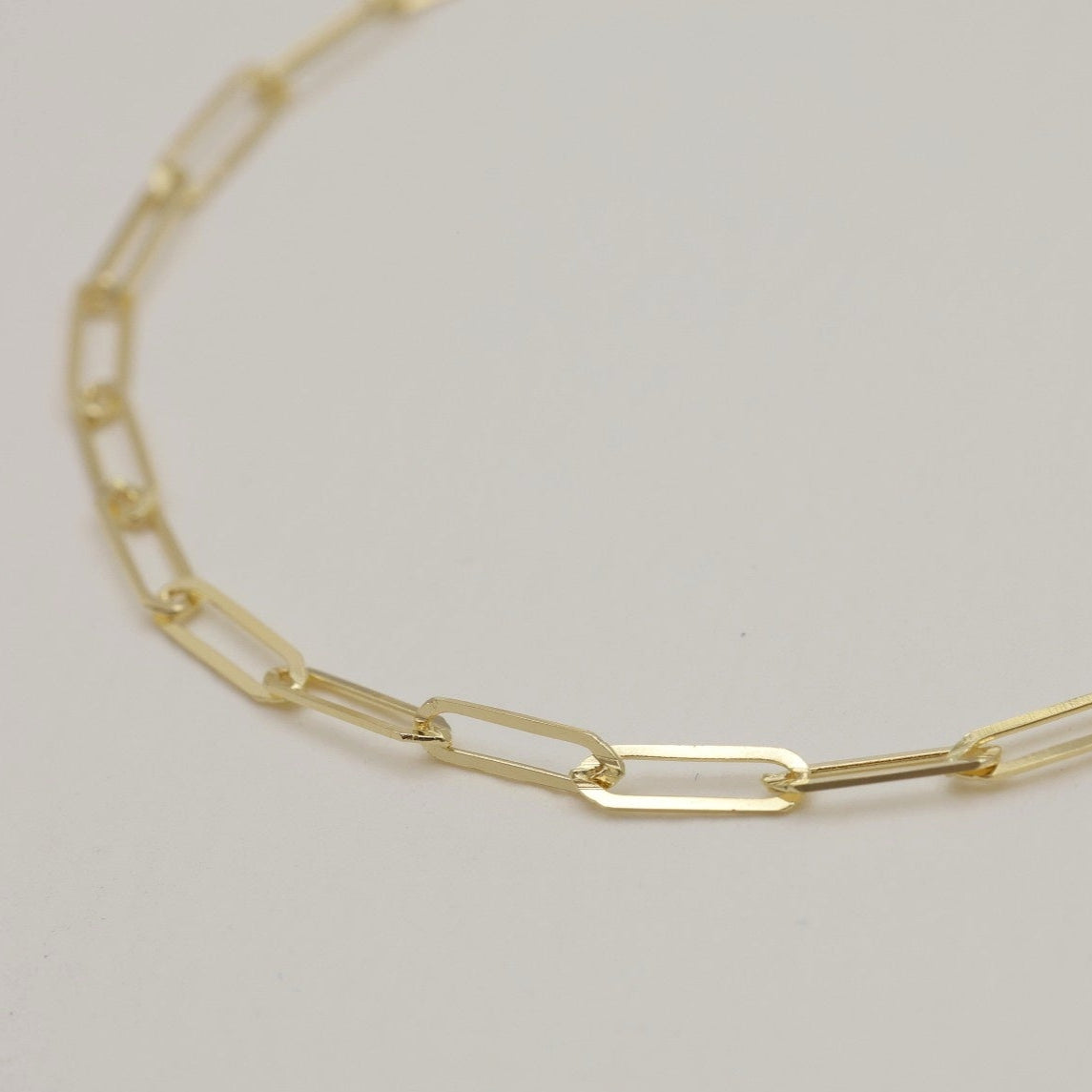 Angled detail of gold rectangular chain links from the Inès 14K bracelet.