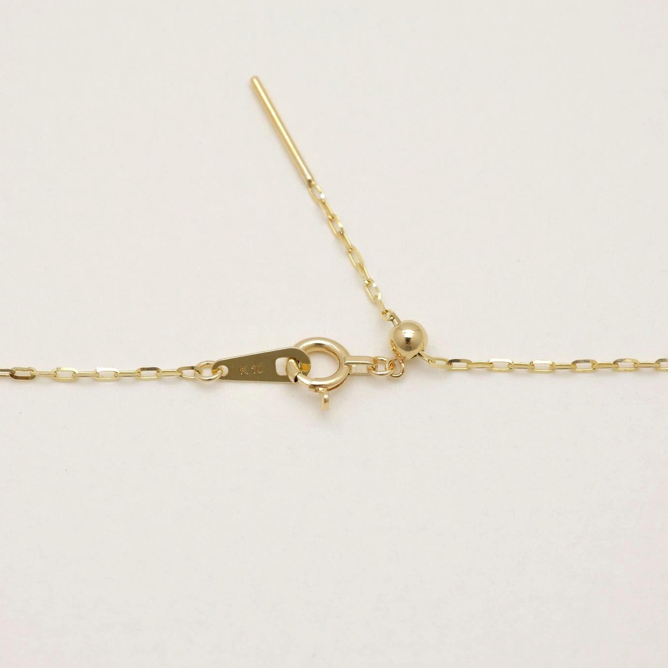 Close-up view of the Juliette Chain Necklace in 10K gold, showing the delicate rectangular links and spring clasp.