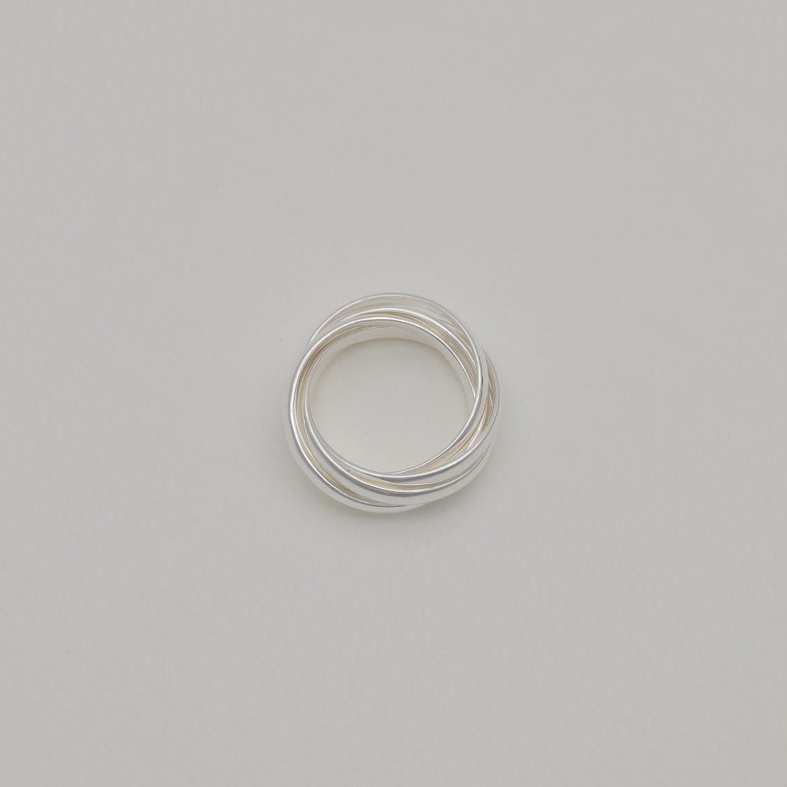 Three interlocking polished sterling silver bands forming a trinity ring