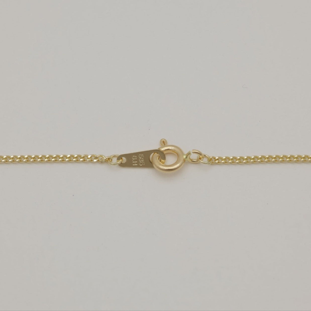 Close-up of the fine gold chain links of the Amélia Necklace
