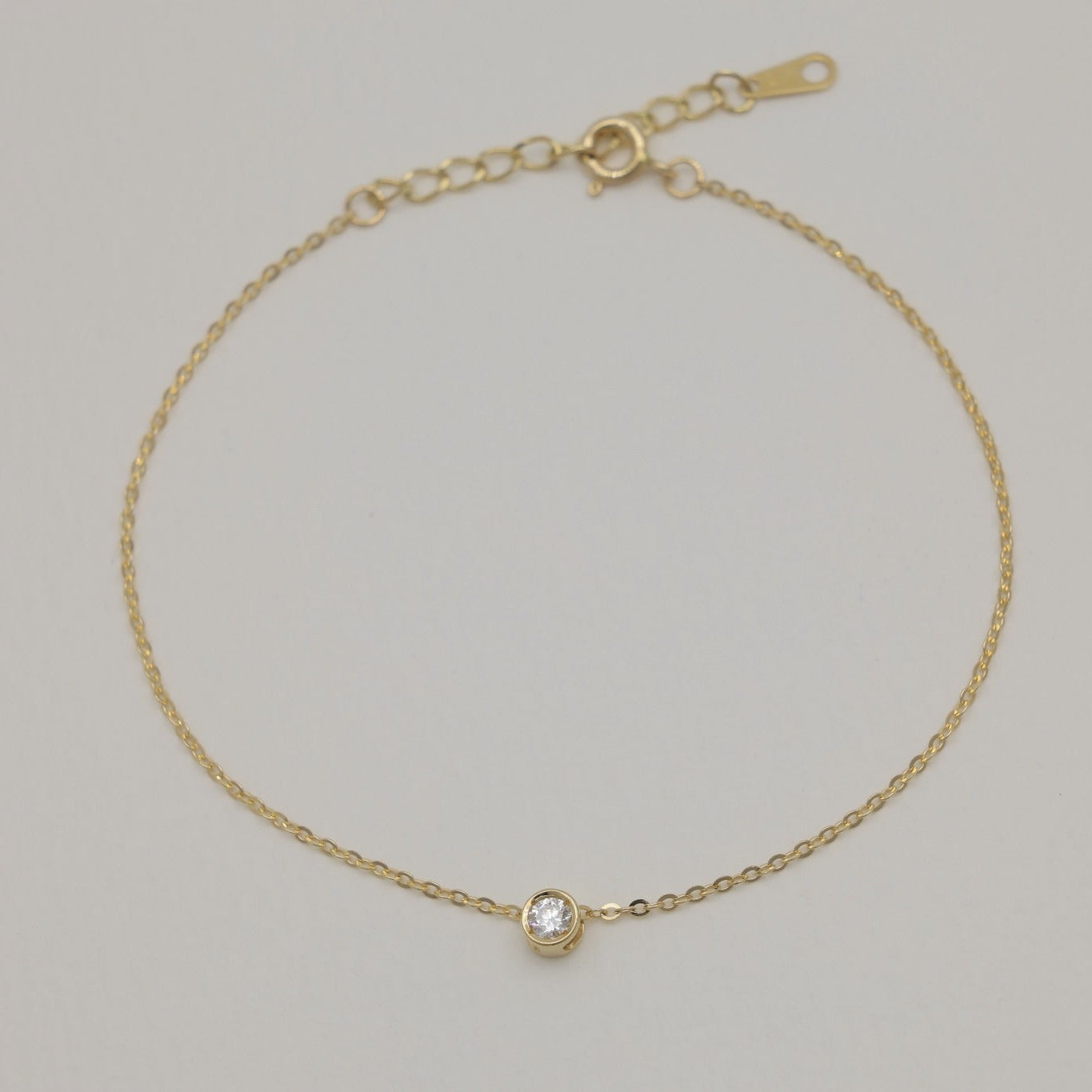 Minimalist gold bracelet with lab-grown diamond bezel set in center