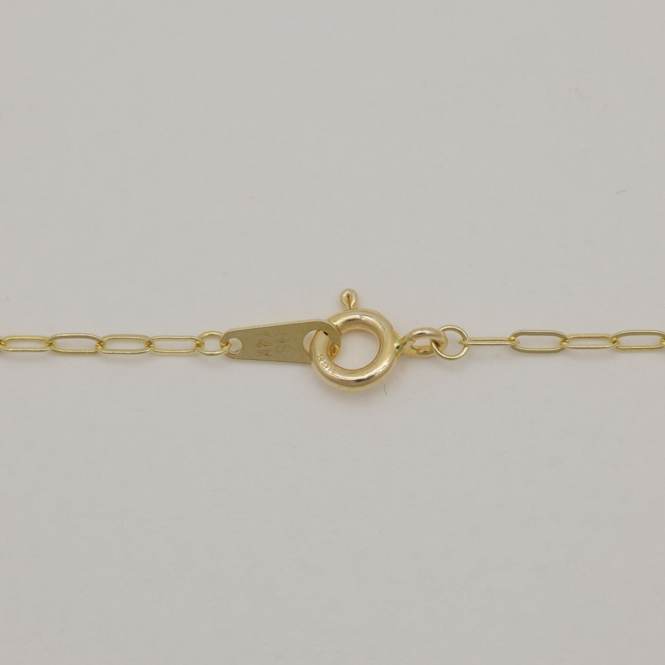Spring ring clasp and 14K hallmark tag detail on the gold chain necklace