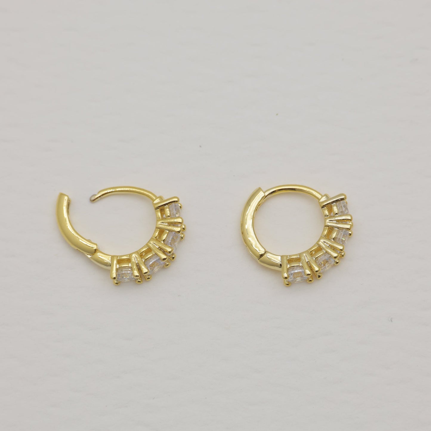 Pair of gold hoop earrings on a light gray background