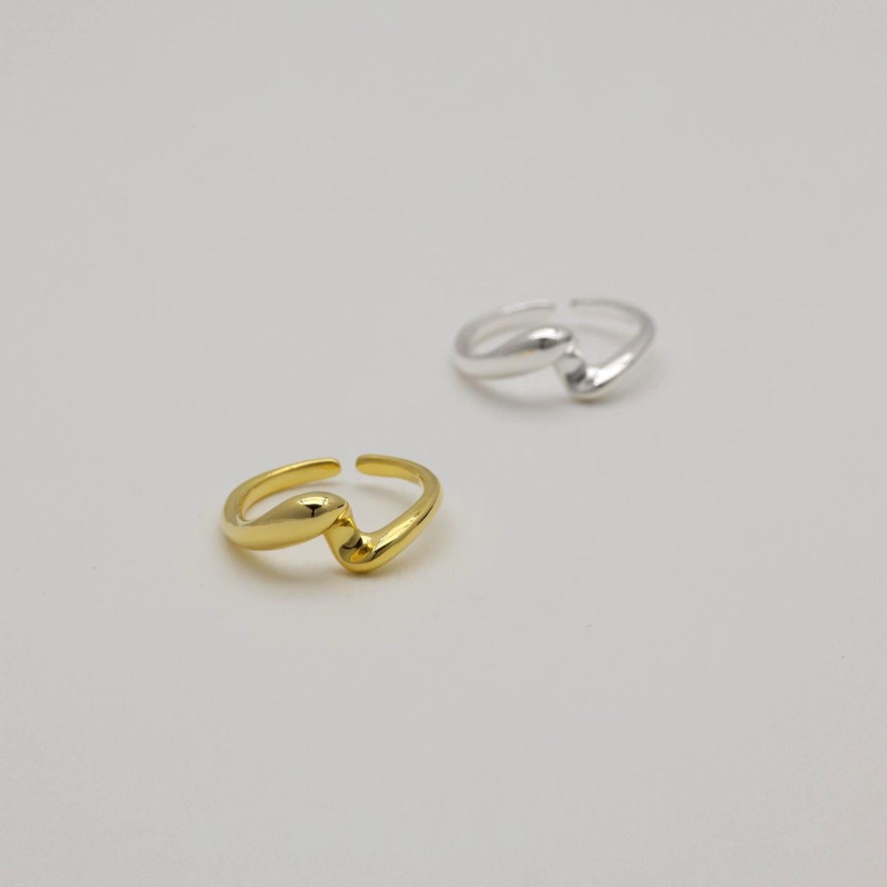 Gold and silver rings on a light gray background