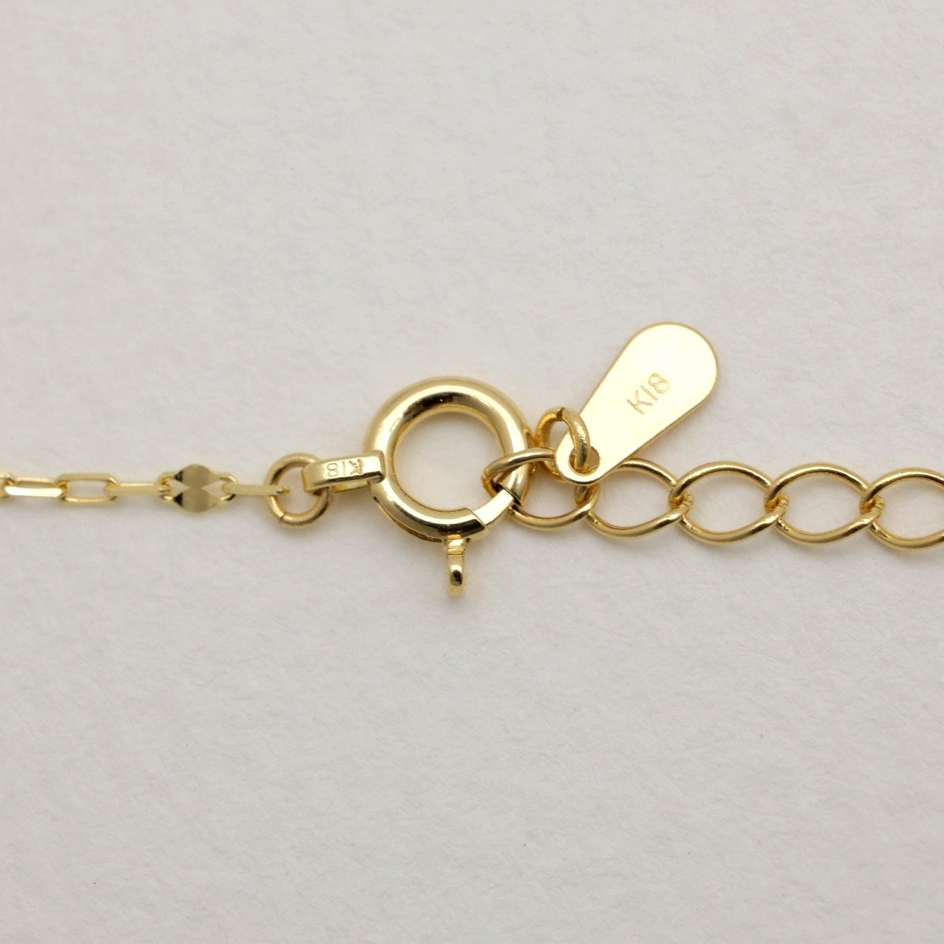 Close-up of 18K gold bracelet clasp and tag stamped K18
