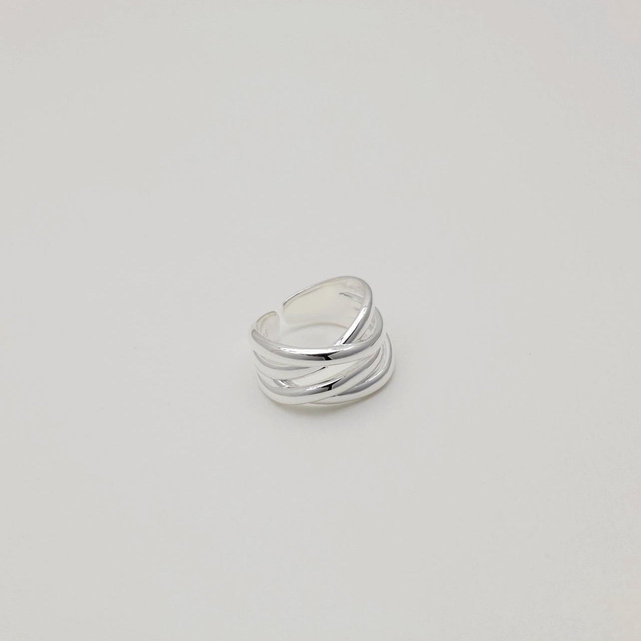 "Sculptural sterling silver ring featuring intersecting high-shine bands"