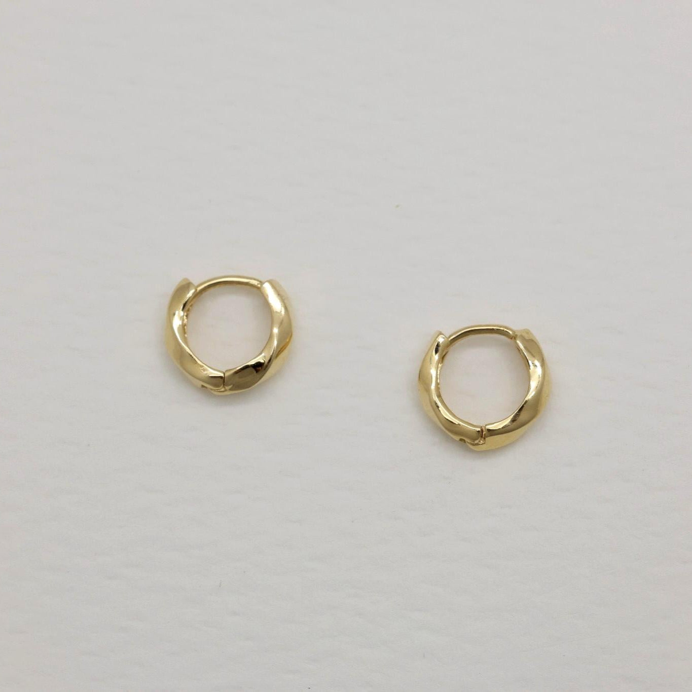 14K gold huggie earrings with softly curved silhouette, photographed on a white background.