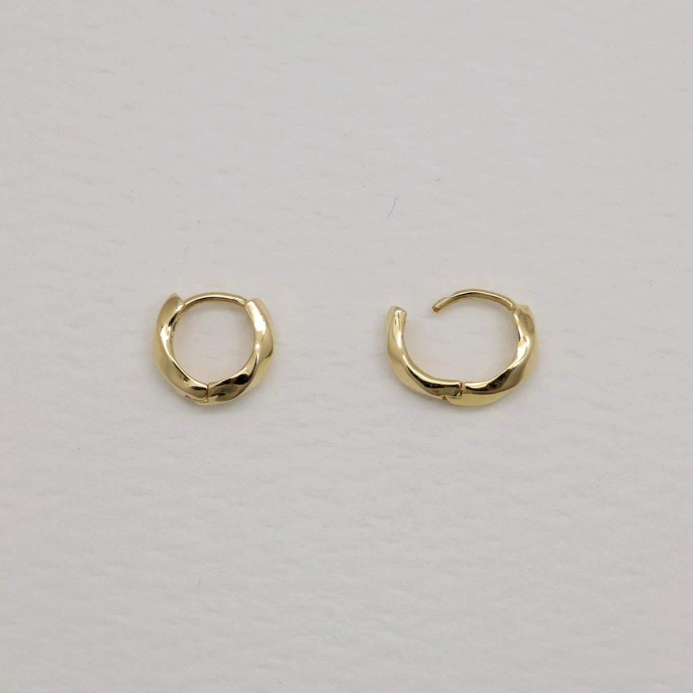 14K gold huggie earrings with softly curved silhouette, photographed on a white background.