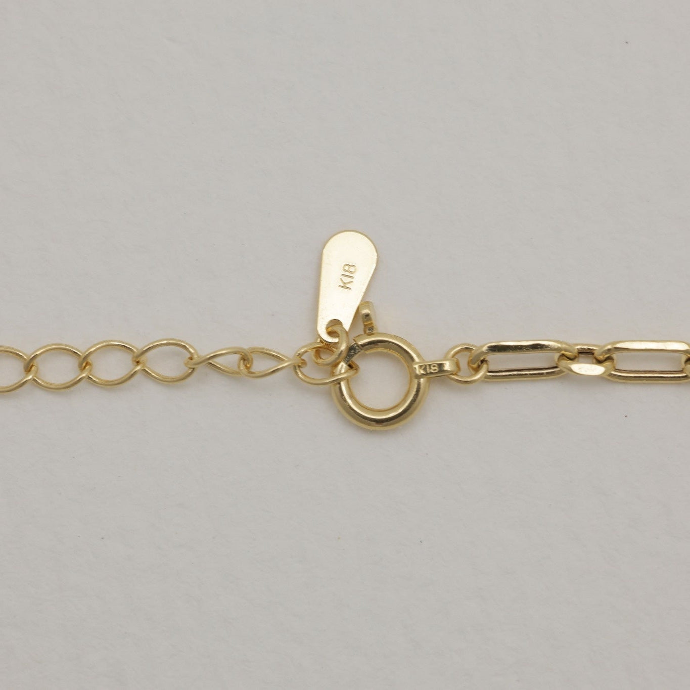Side view of 18K gold bracelet with oval extender loops