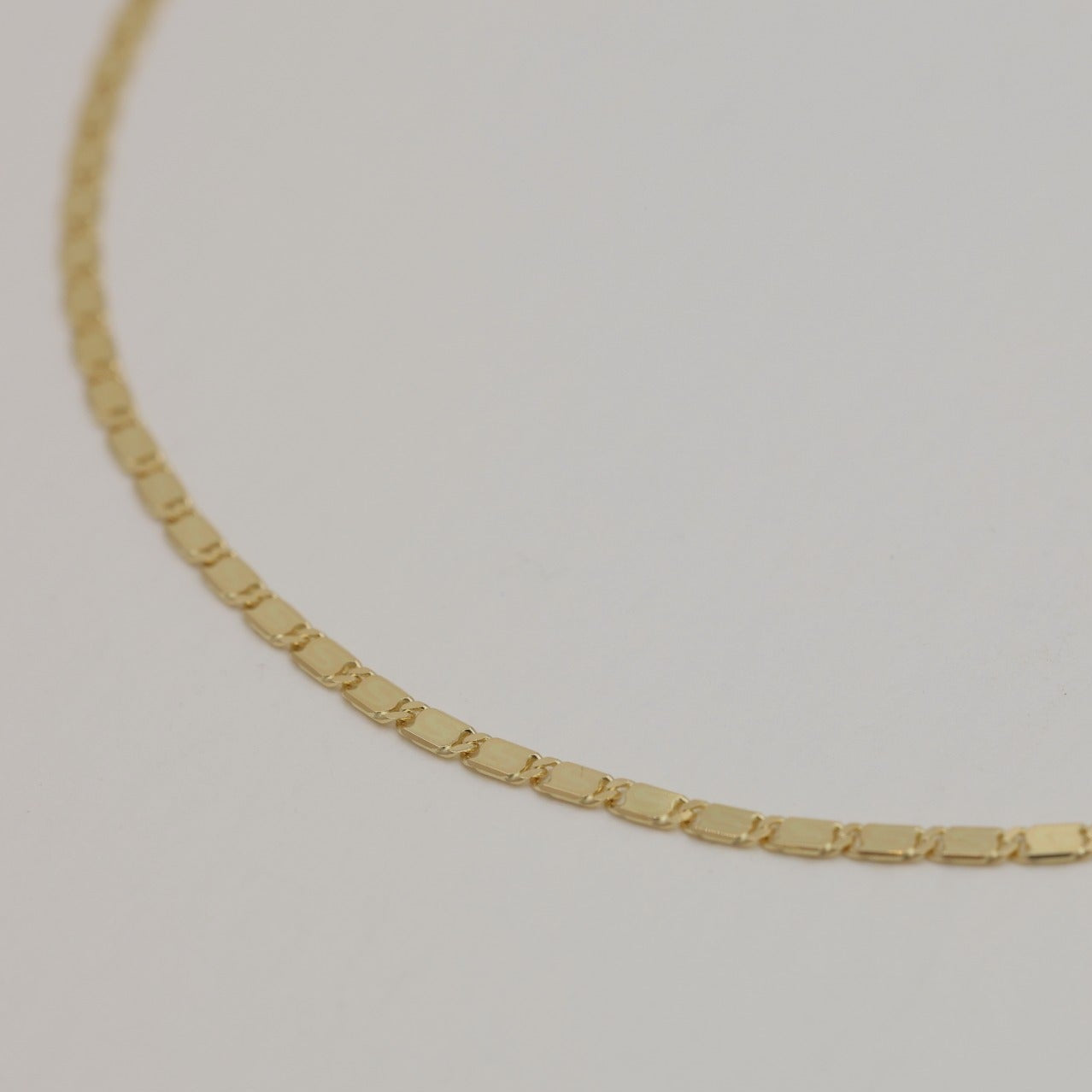 Close-up of polished gold links of 14K bracelet showing texture and shine.