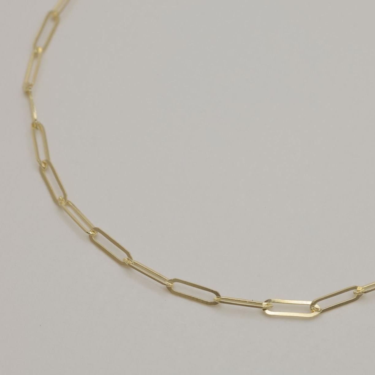 Close-up of 14K gold chain links with soft lighting showing polished finish