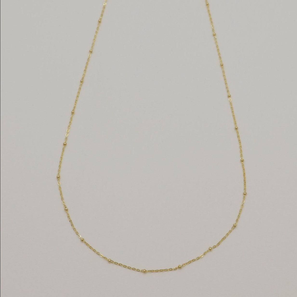 Full view of Maëlle 14K gold necklace with delicate bead accents