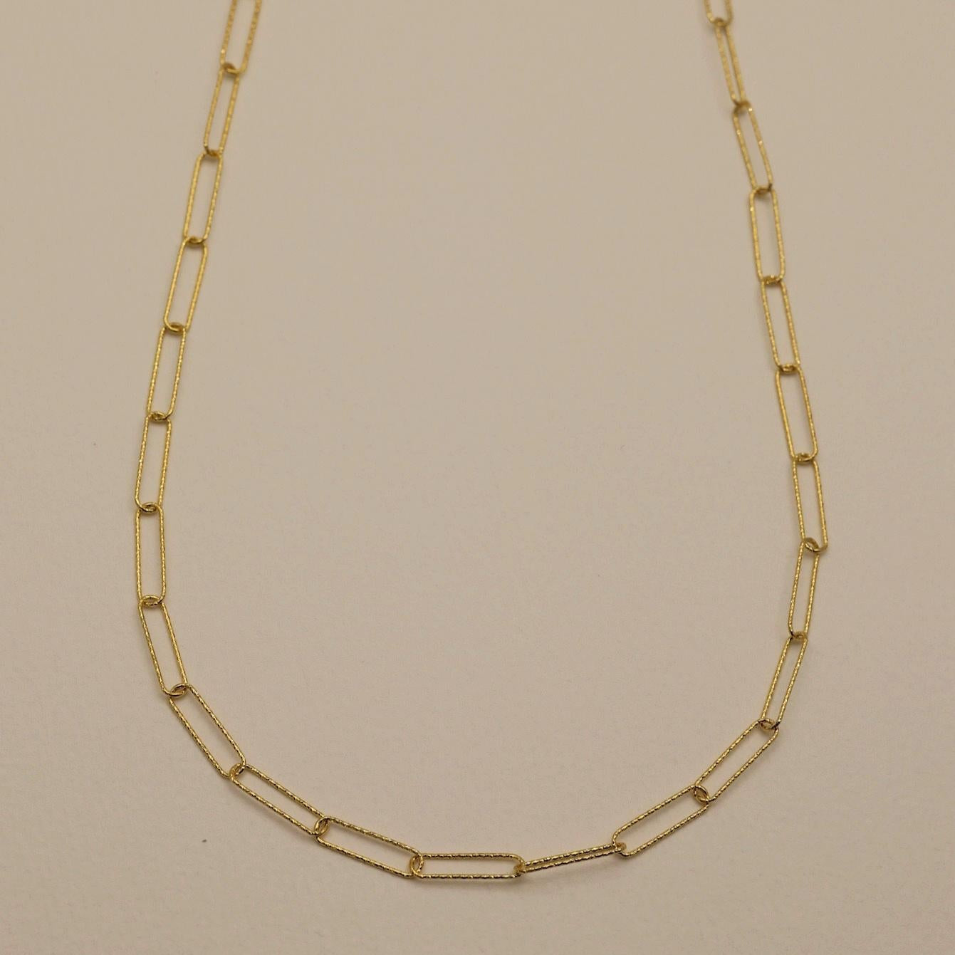 A long 70cm gold vermeil necklace with elongated rectangular links, styled in a minimalist Y-shape.