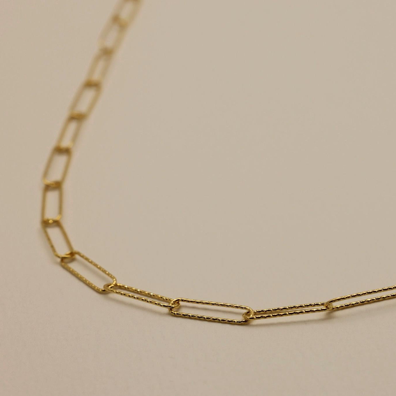 Textured rectangular chain links in polished gold vermeil, showing fine craftsmanship
