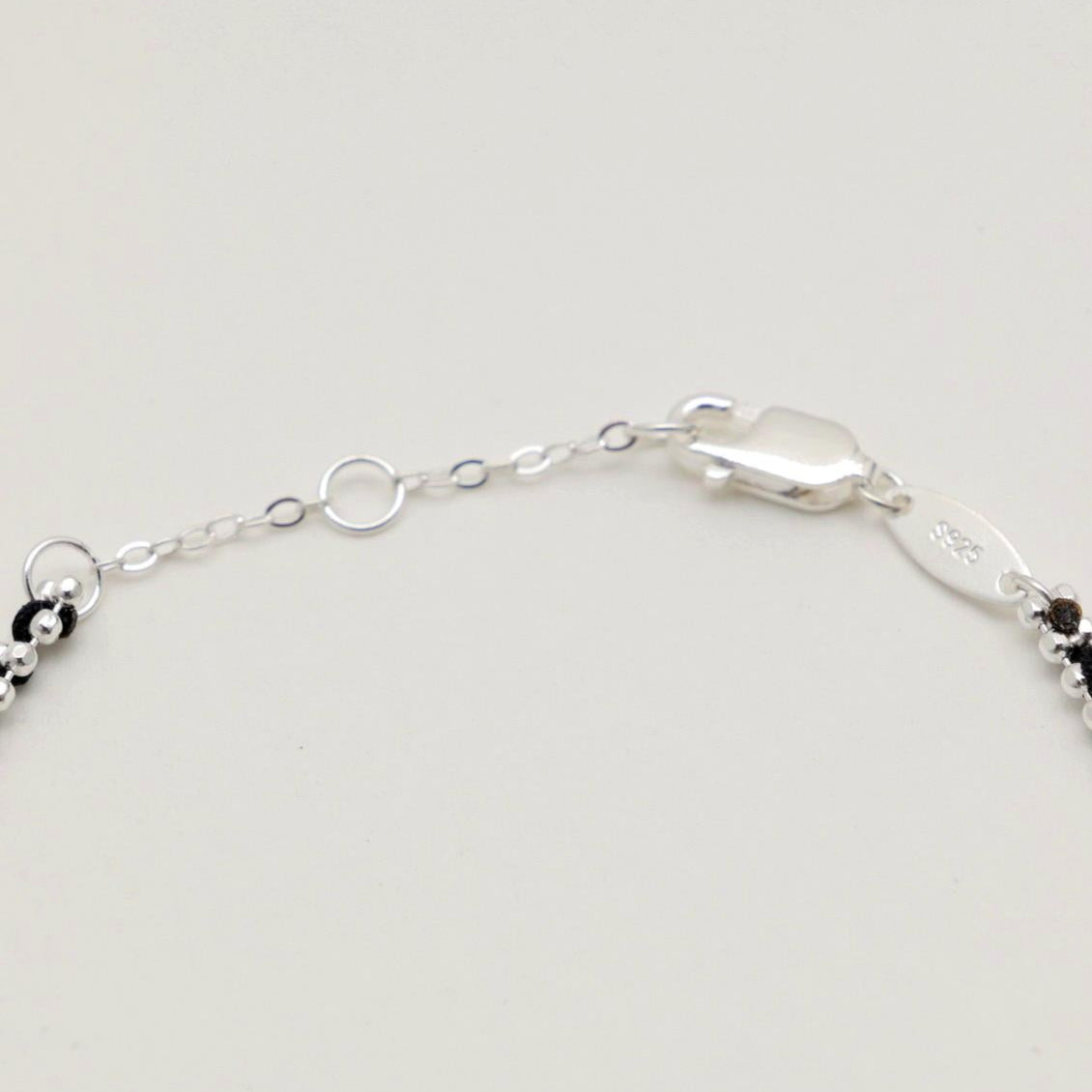 Close-up of the lobster clasp and 925 hallmark tag on the Agnès sterling silver bracelet.