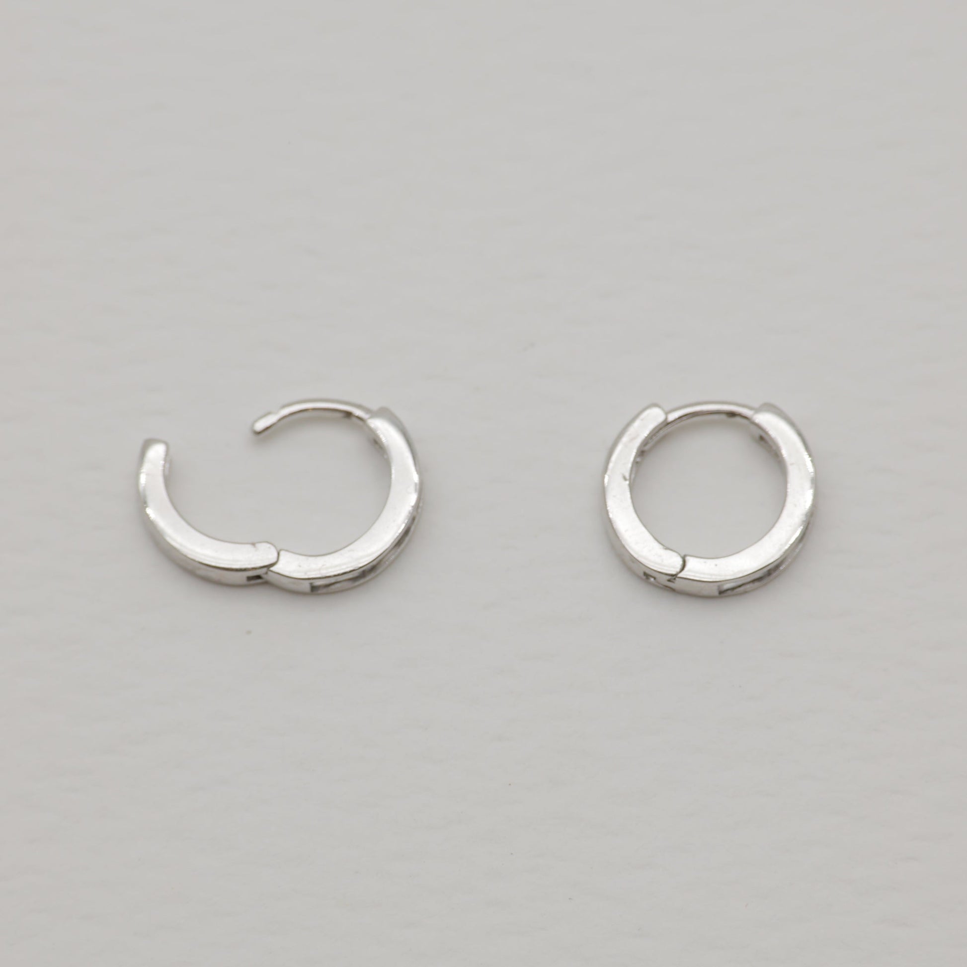 Pair of silver hoop earrings on a gray background