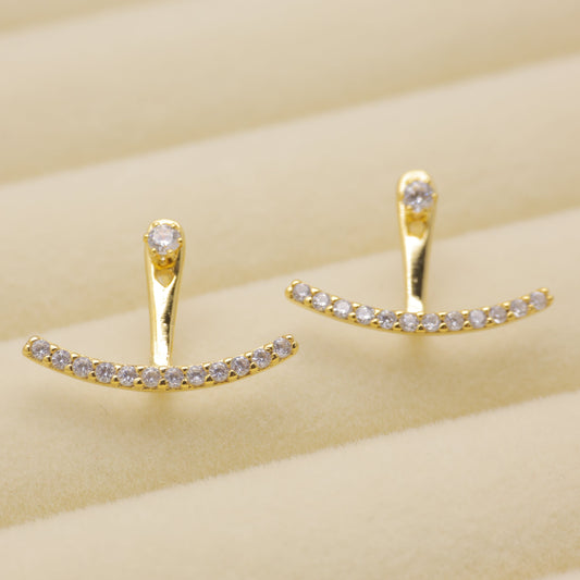 Gold earrings with small diamonds on a beige background