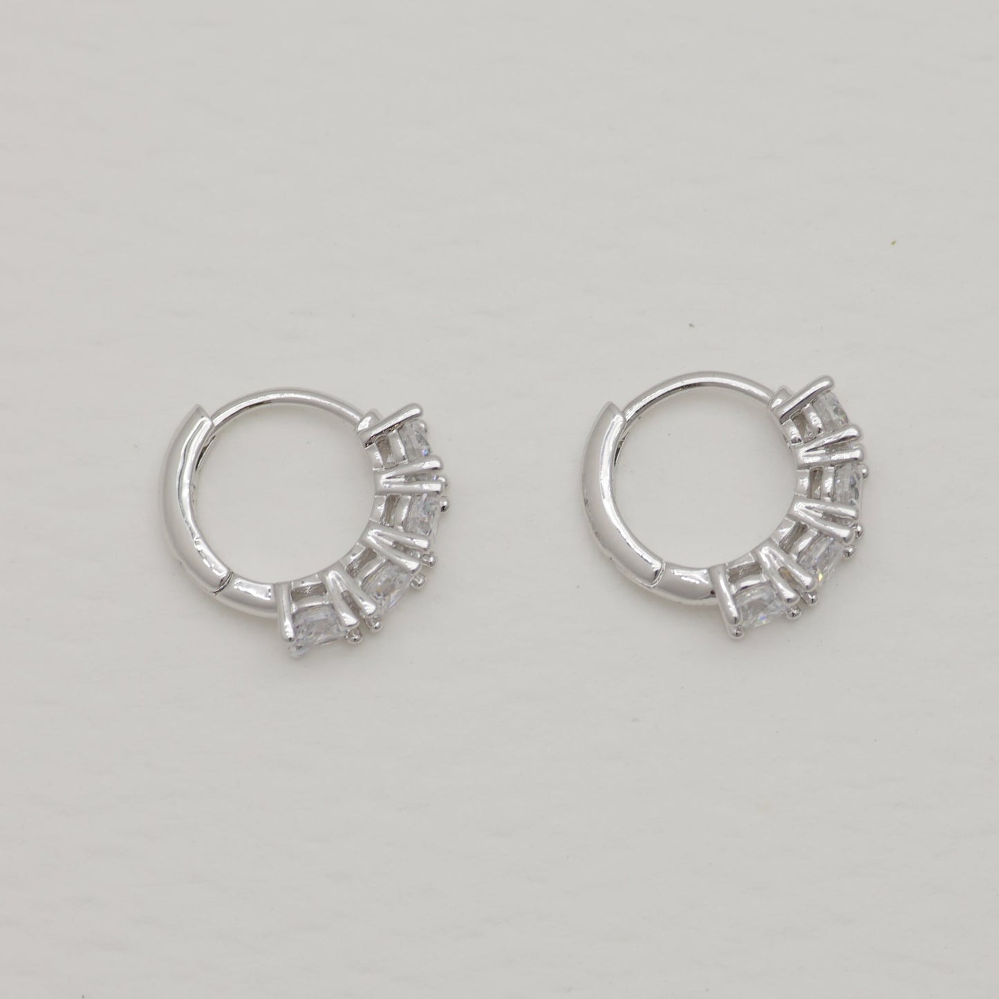 Pair of silver hoop earrings on a light gray background