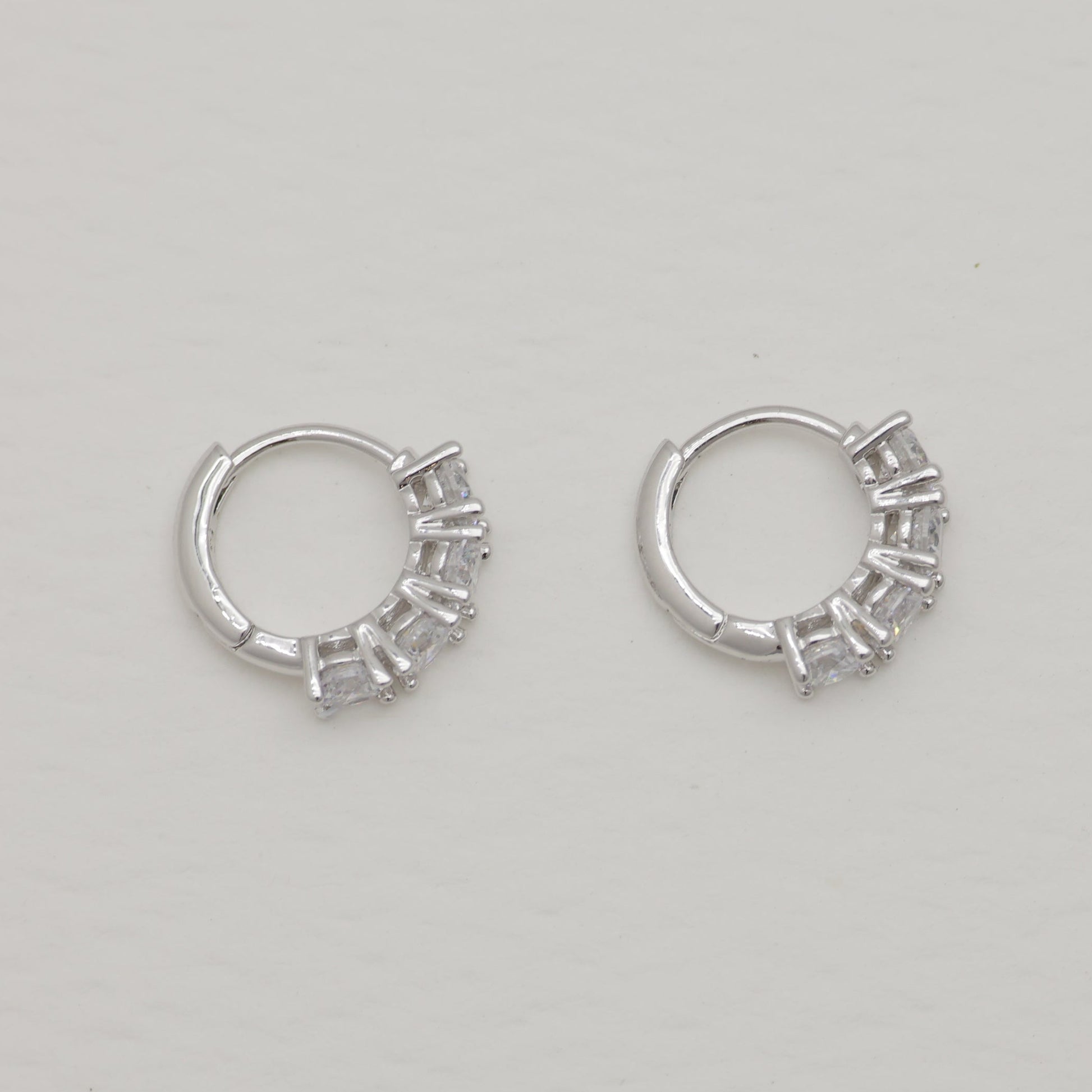 Pair of silver hoop earrings on a light gray background