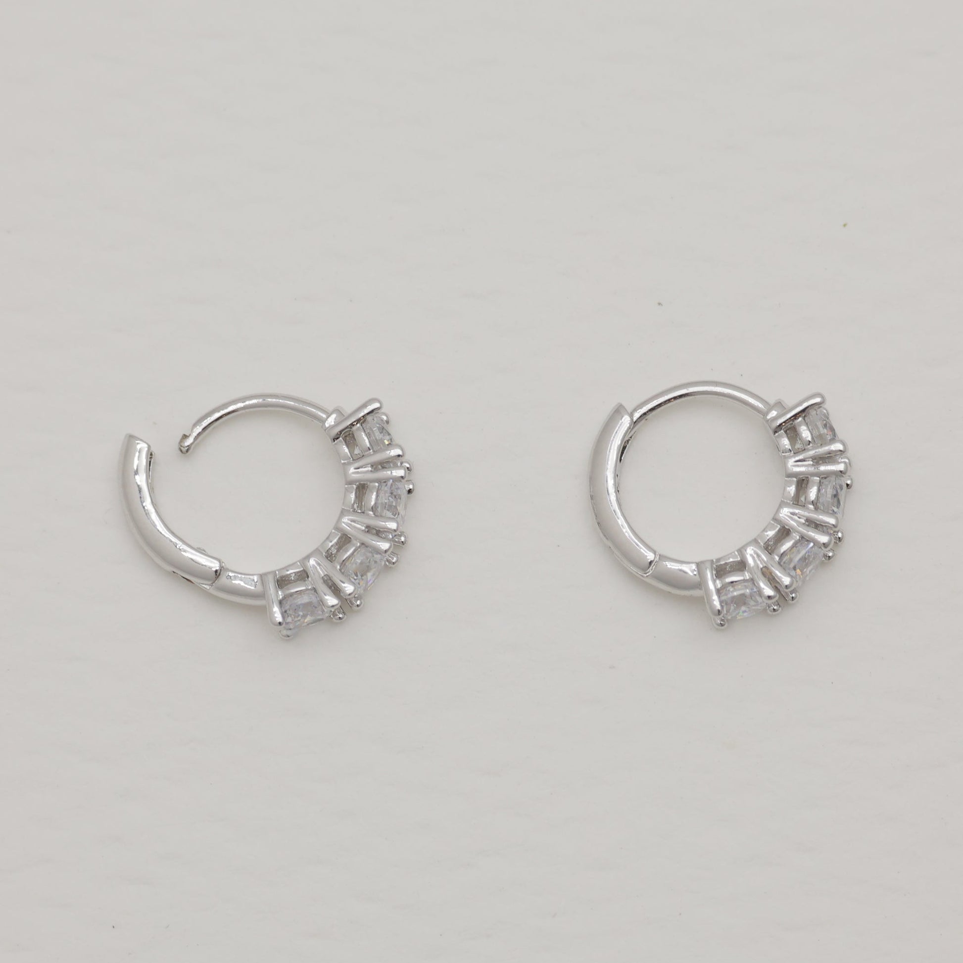 Pair of silver hoop earrings on a light gray background