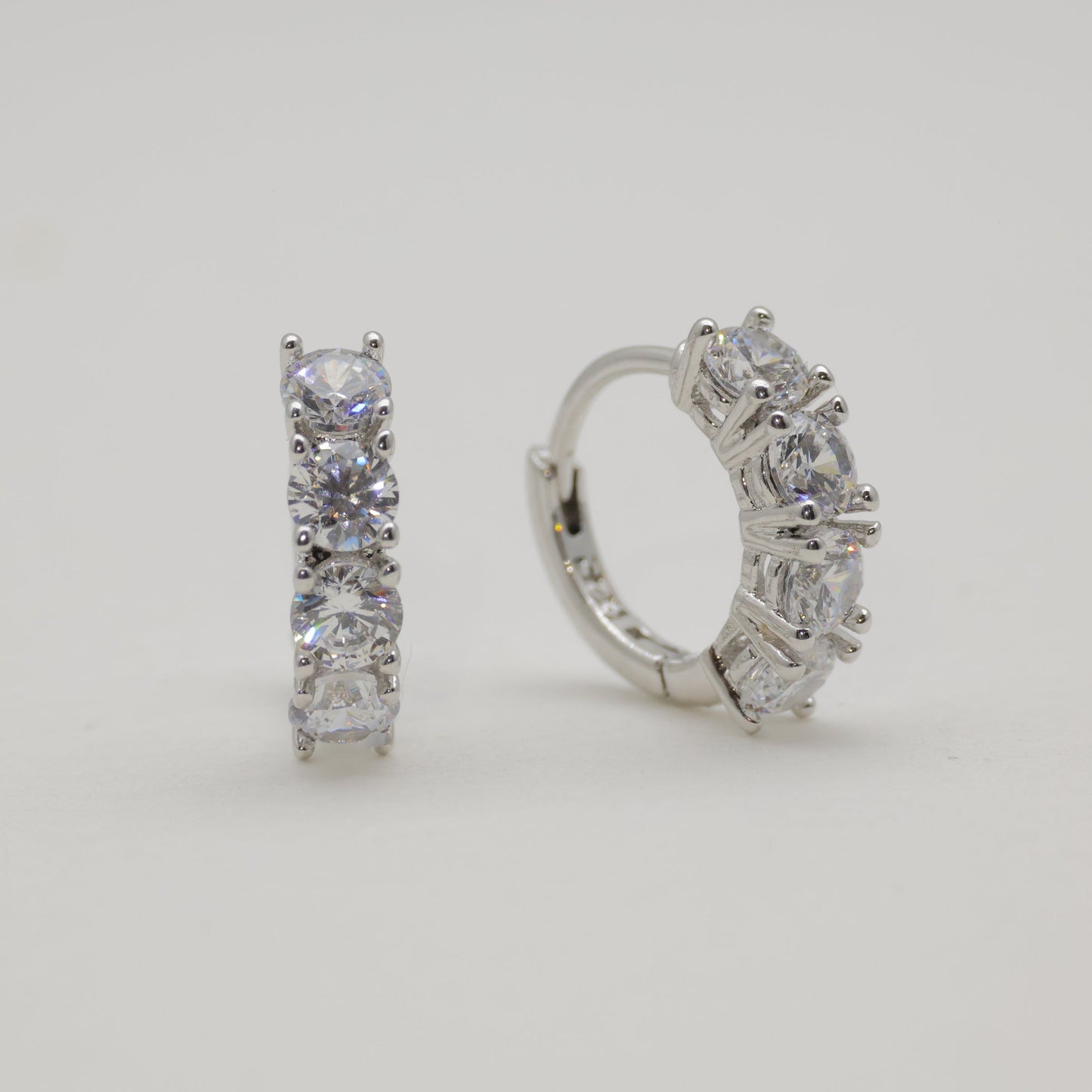 Pair of diamond hoop earrings on a light gray background