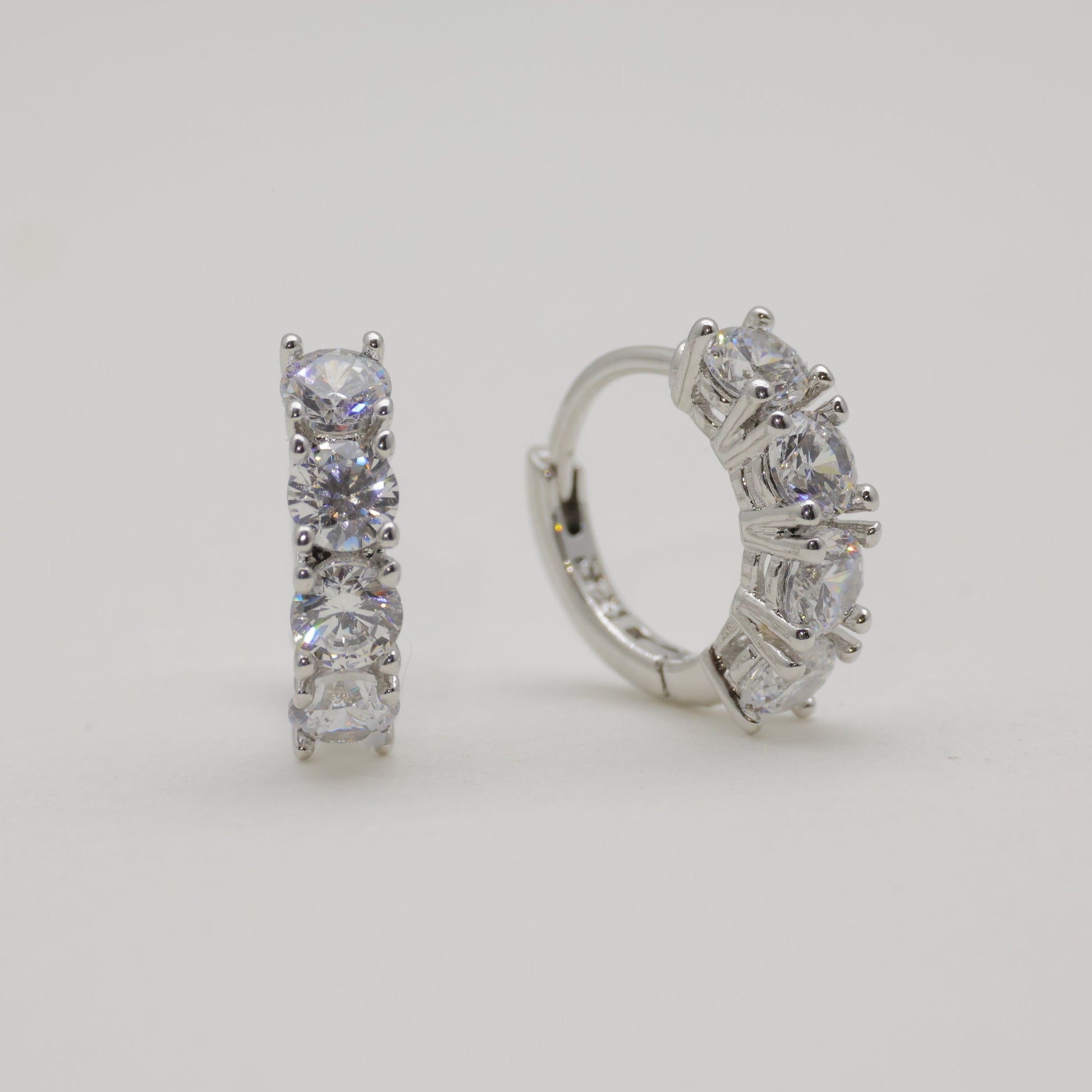 Pair of diamond hoop earrings on a light gray background