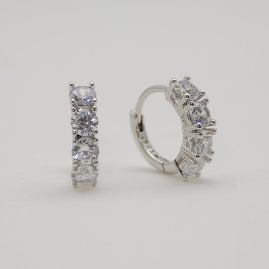 Pair of diamond hoop earrings on a light gray background