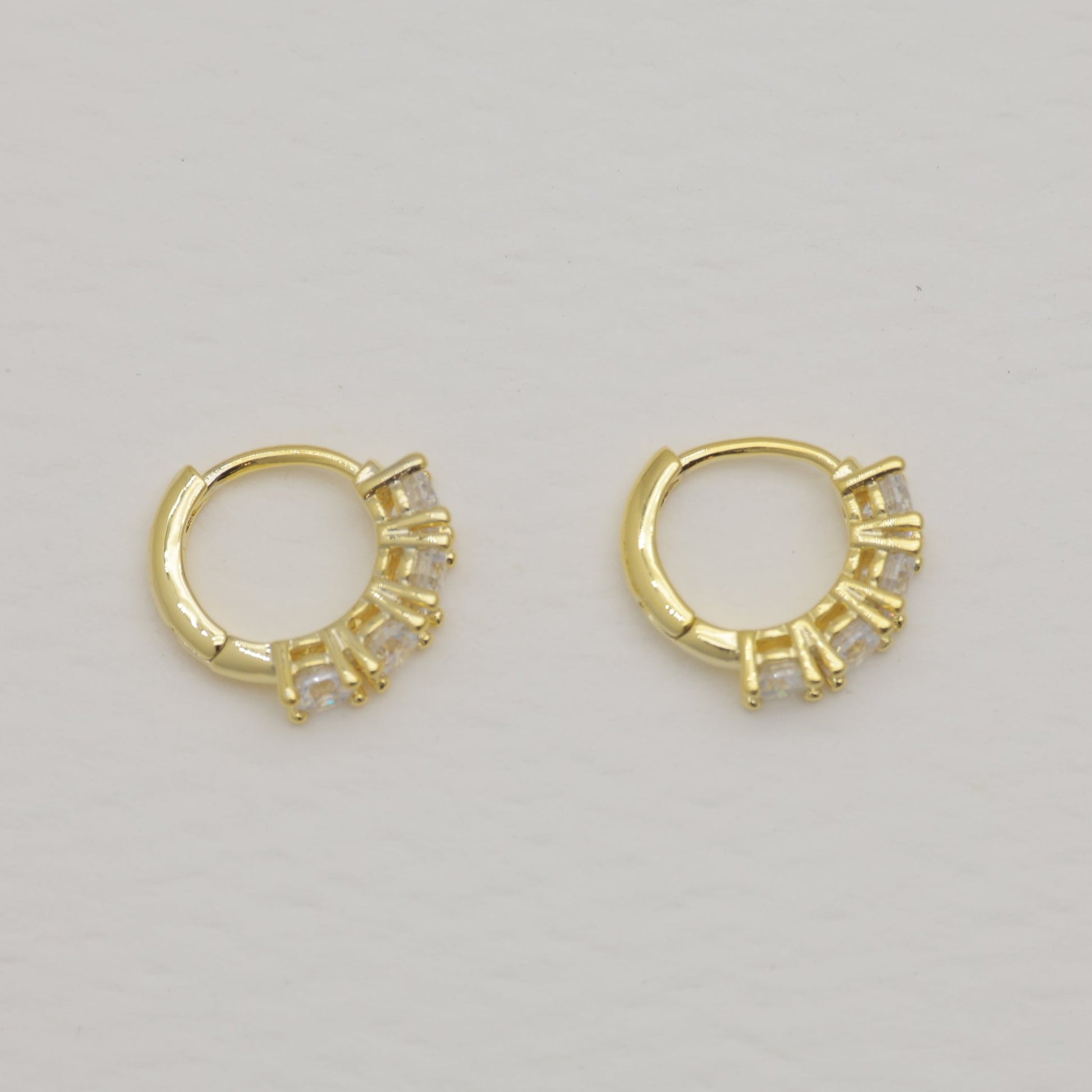 Pair of gold hoop earrings on a light gray background