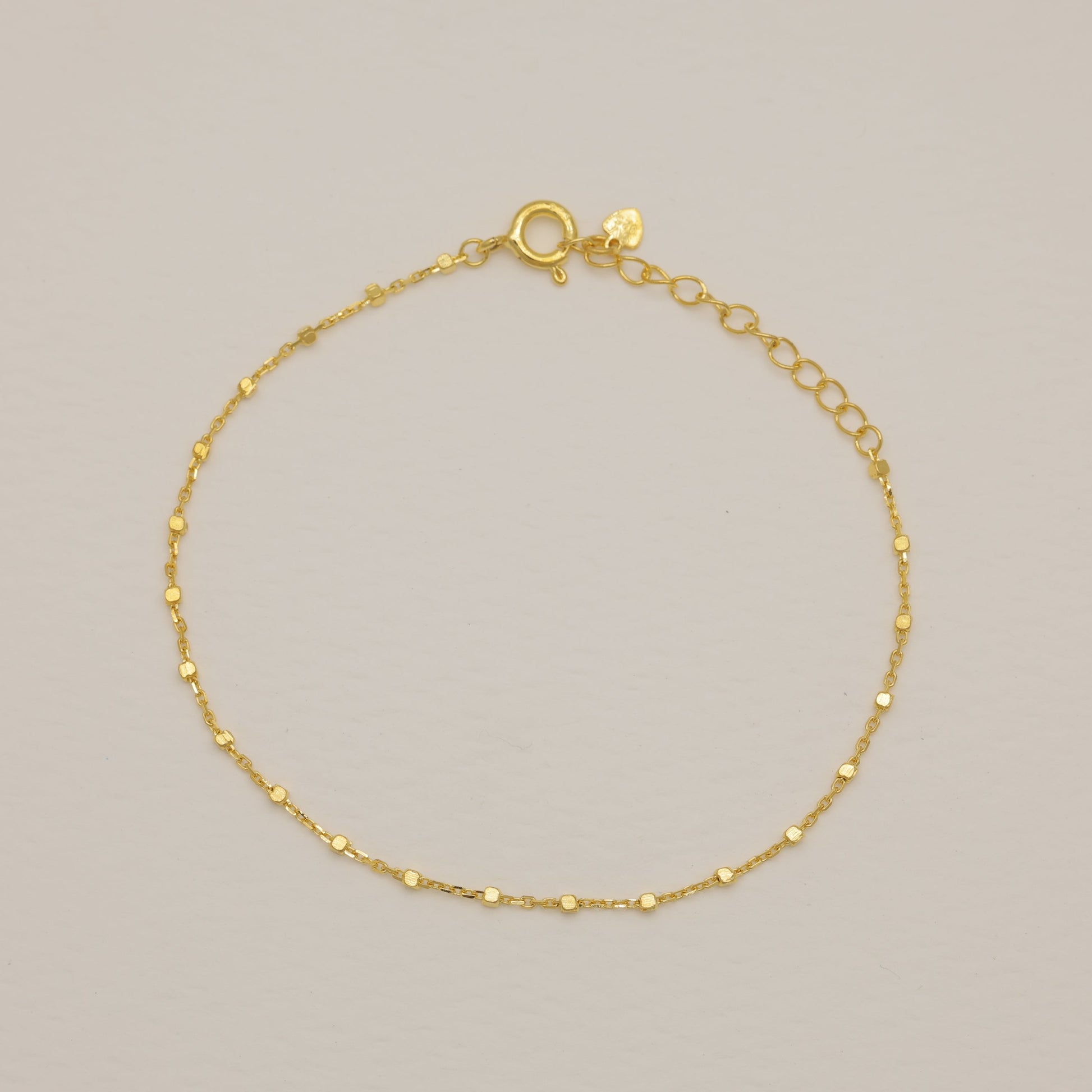 Gold bracelet on a light gray background