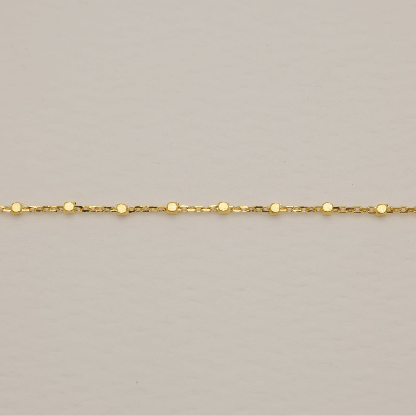 Gold chain on a beige background