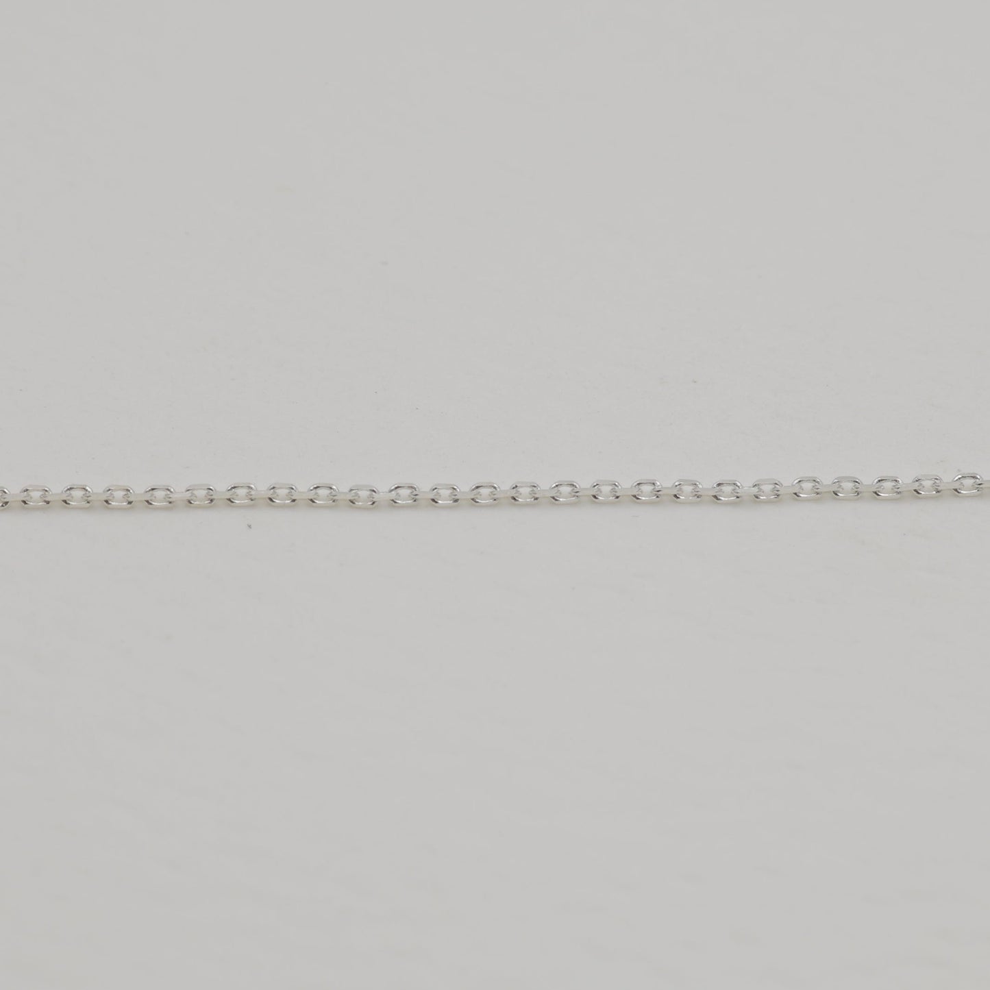Fine sterling silver chain close-up on neutral background.