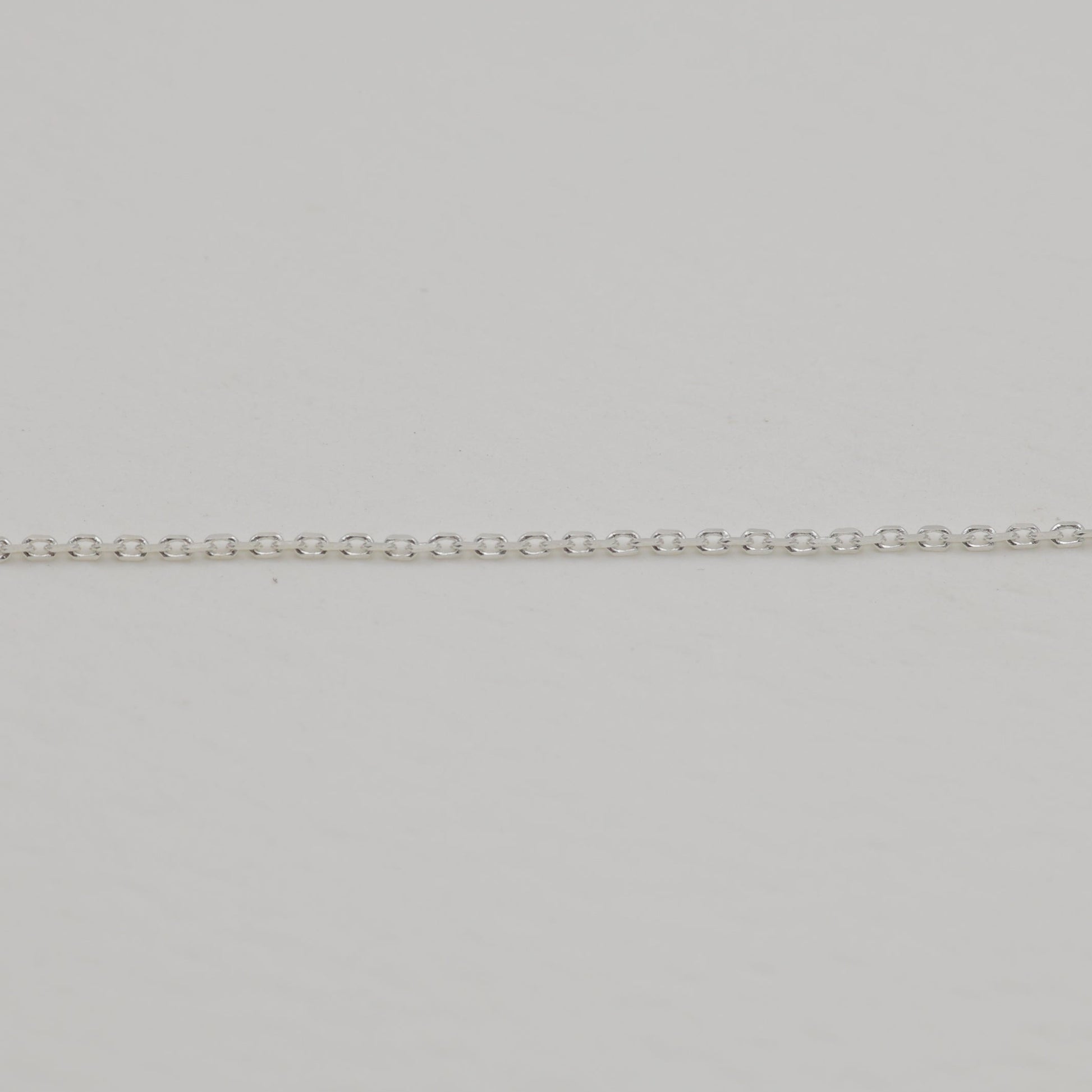 Fine sterling silver chain close-up on neutral background.